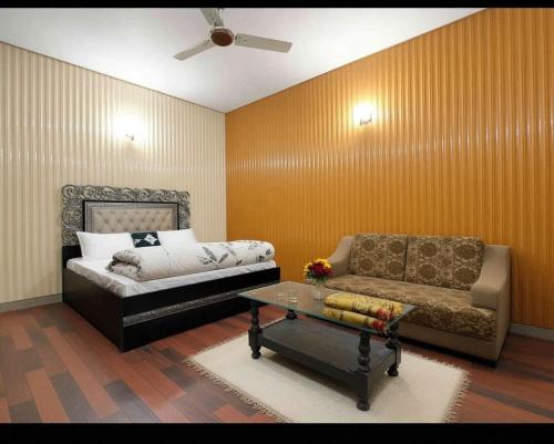 a living room with a bed and a couch at AGH Guesthouse & Rooms in Islamabad