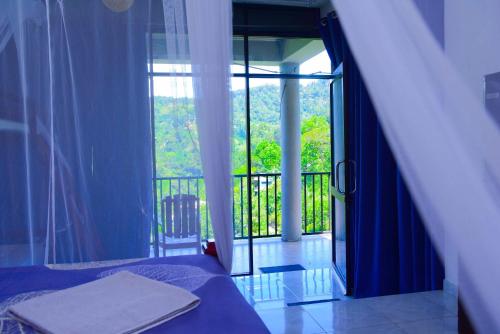 a bedroom with a bed and a balcony with a window at Viewfront Ella in Ella