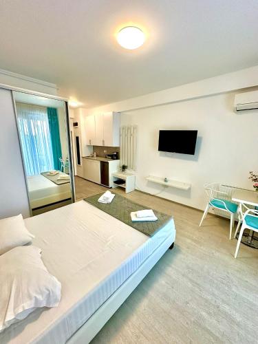 a bedroom with a large bed and a tv on the wall at Mario Summerland Property in Mamaia