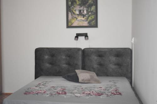 a bed with a gray headboard and a pillow on it at Апартамент за гости Лале in Lovech
