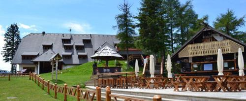 a building with tables and chairs in front of a building at Hotel Krvavec in Cerklje na Gorenjskem