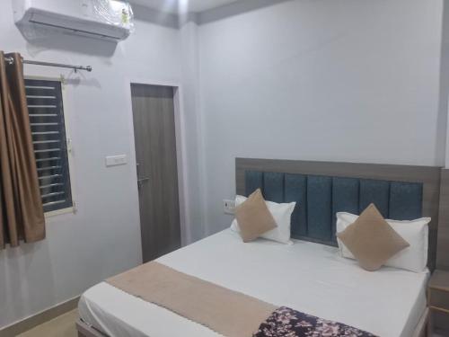 a bedroom with a bed with white sheets and pillows at HOTEL KRISHNAM Inn in Mathura