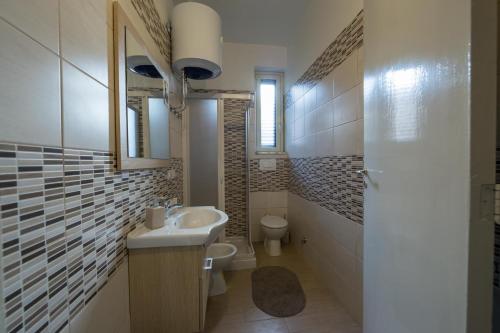 une salle de bain blanche avec un lavabo et des toilettes dans l'établissement La casa di Eolo, à Villa San Giovanni