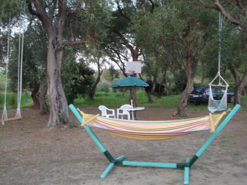 a hammock with a table and an umbrella in a park at Tasia Studios in Perivolion