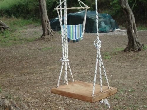 a swing with a wooden board in a park at Tasia Studios in Perivolion