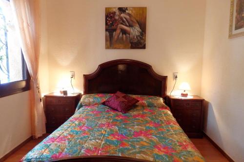 1 dormitorio con 1 cama con un edredón colorido en MEDDAYS VILLA ROCIO, en Miami Platja