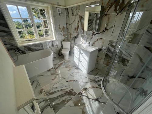 a bathroom with a shower and a toilet and a sink at Recently renovated Lodge Cottage, Quantocks in West Bagborough