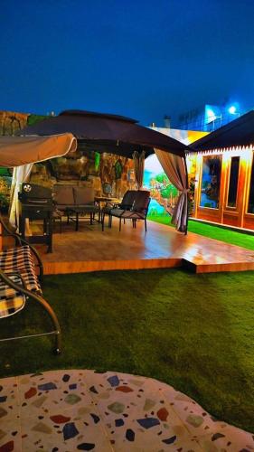 a patio with tables and chairs under a tent at أكواخ واستراحه ريف عسير in Abha