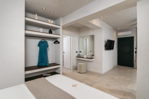 a bedroom with a bed and a blue dress on a shelf at Ostria Vento in Pollonia