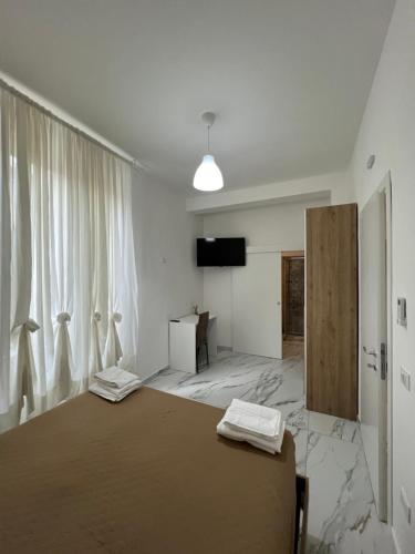 a white room with a bed and a television at Corte Moscara Vasto Centro in Vasto