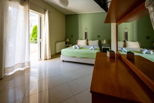 a bedroom with two beds and a large window at Villa Muses in Poros