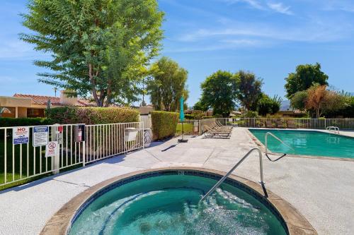 a swimming pool with a hot tub in a yard at Palm Paradise in Palm Desert