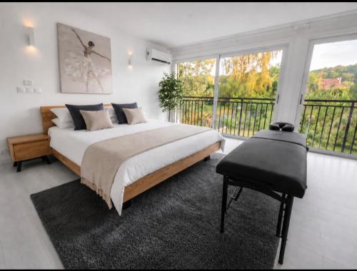 a bedroom with a large bed and a balcony at Frida's house in Bièvres