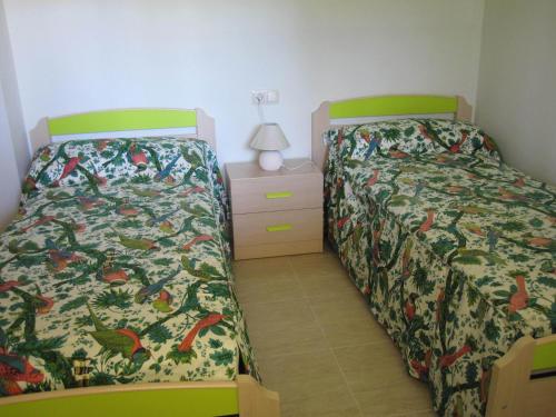 1 dormitorio con 2 camas y mesita de noche con lámpara en Luz de Azahar Bed and Breakfast, en Peñíscola