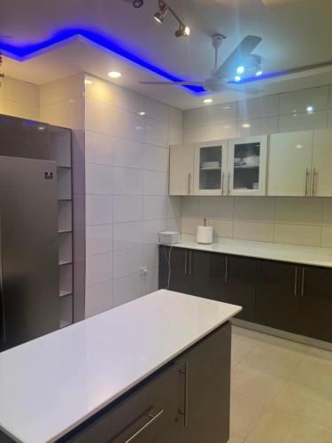 a kitchen with white countertops and a blue ceiling at Kingdom home in Amanfro