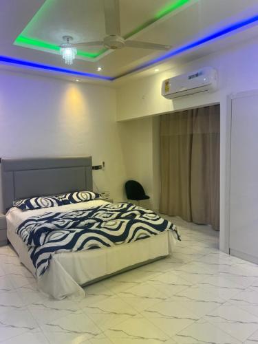 a bedroom with a bed with green lights on the ceiling at Kingdom home in Amanfro