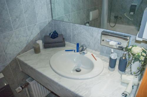 a bathroom with a white sink and a mirror at Kempe Komfort plus Hotel in Solingen