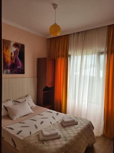 a bedroom with a large bed and a large window at MAG house in Shekhvetili