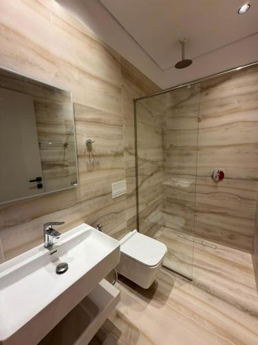 a bathroom with a toilet and a sink and a shower at The Factory Boutique in Vlorë