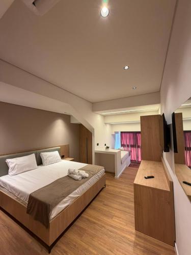 a bedroom with a large bed and a television at The Factory Boutique in Vlorë