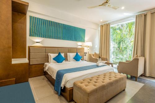a bedroom with a large bed and a chair at Mainland Resorts & Spa by Kolaahalam in Yercaud
