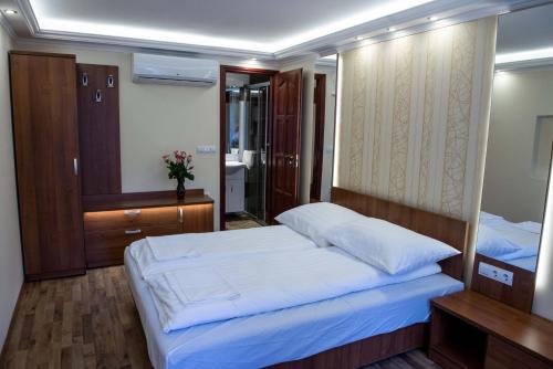ein Schlafzimmer mit einem großen Bett und einem Spiegel in der Unterkunft BL.Apartmanház II. in Szeged