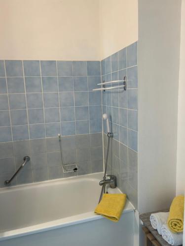 a bathroom with a bath tub with blue tiles at Studio ensoleillé avec piscine in Cazaubon