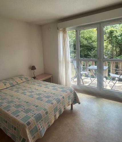 a bedroom with a bed and a view of a patio at Studio ensoleillé avec piscine in Cazaubon