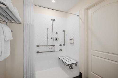 a white bathroom with a shower and a sink at Holiday Inn Victoria - Elk Lake by IHG in Victoria