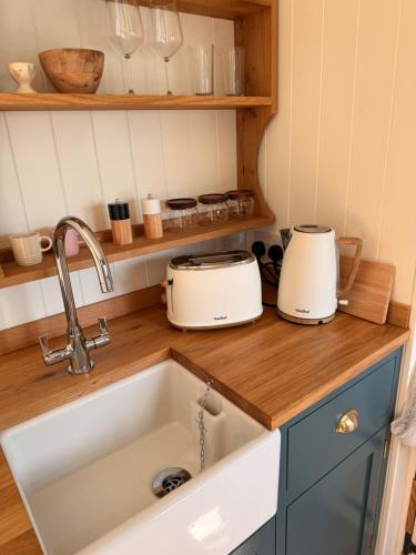 a kitchen sink with two toasters on a counter at Shepherds Hut in St Austell