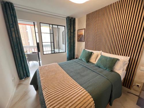 a bedroom with a bed and a large window at BENILOVE en playa VUE MER Panoramique in Benidorm
