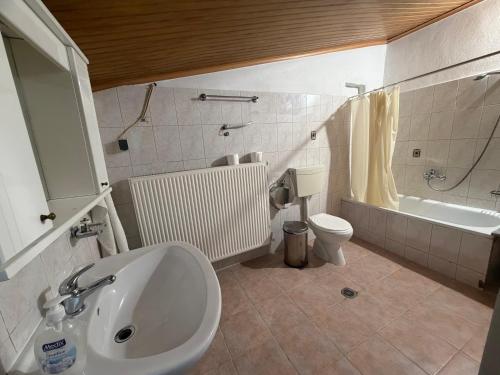 a bathroom with a sink and a toilet and a tub at Monastiraki Villa in Keramoti