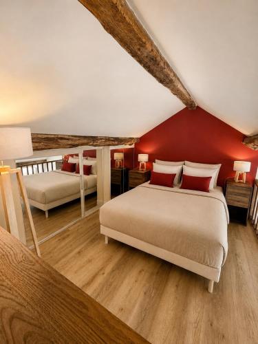 a bedroom with two beds and a red wall at Charming Duplex by Vincennes Castle in Vincennes