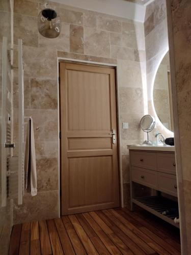 a bathroom with a wooden door and a sink at Casa Oksana in Castelnau-de-Montratier