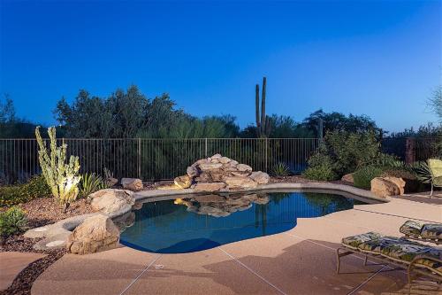 a swimming pool with rocks in a yard at Caledonia Dreamin in Phoenix