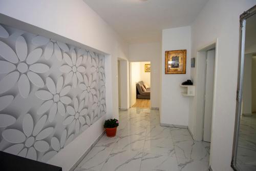 a hallway with a wall with a flower pattern on it at Apartmani Jasna in Omiš