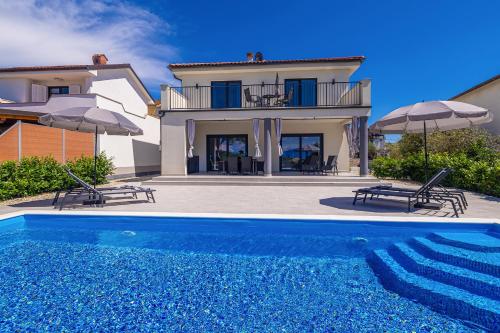 a villa with a swimming pool in front of a house at Villa MARIS with private pool in Sveti Vid-Miholjice
