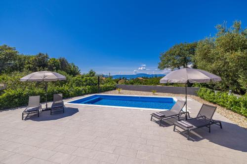 a swimming pool with two chairs and two umbrellas at Villa MARIS with private pool in Sveti Vid-Miholjice
