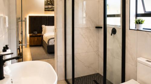 a bathroom with a shower and a toilet and a sink at Regent Heights Hotel in Johannesburg