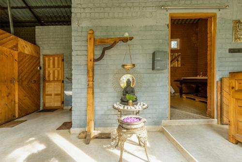 a room with a table and a lamp on a wall at Mainland Resorts & Spa by Kolaahalam in Yercaud