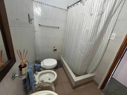 a small bathroom with a toilet and a shower at La Casita de Levene en Lobos in Lobos