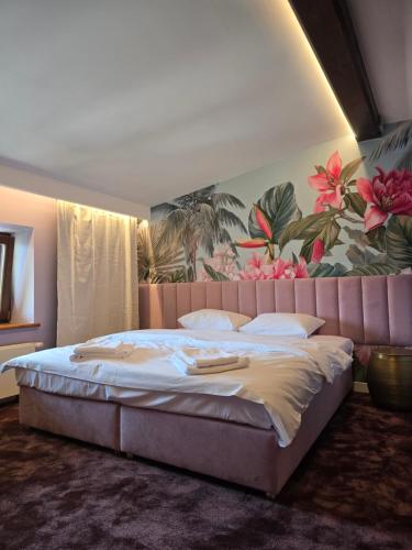 a bedroom with a large bed with a painting on the wall at Hotel i Restauracja Pałacyk Tyrolski in Żyrardów