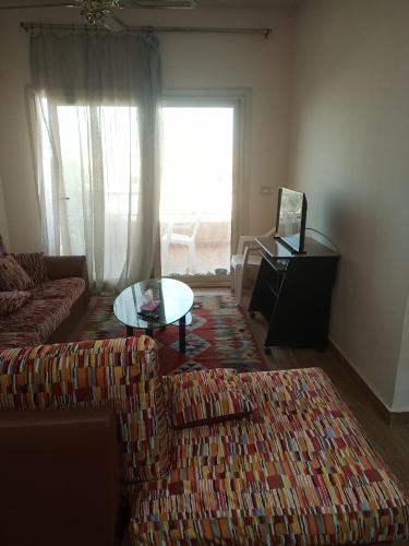 a living room with a couch and a table and a window at Tahiti North coast kilo 62 in Borg El Arab