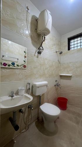 a bathroom with a toilet and a sink and a mirror at Sangeetha Private Pool Villa in Auroville