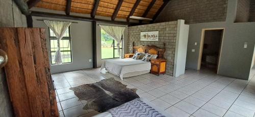 a bedroom with a bed and a table in a room at Daisy Lodge in Barberton