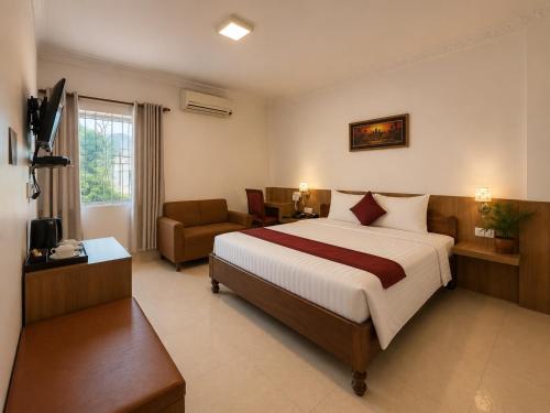 a hotel room with a large bed and a couch at The One by Nika in Siem Reap