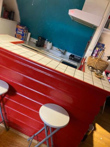 a red counter with two stools in a kitchen at Cœur de Troyes studio in Troyes