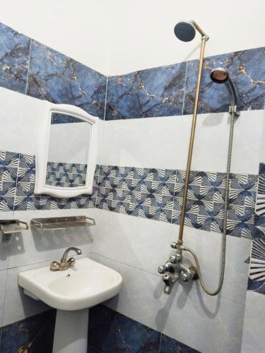 a bathroom with a sink and a shower at Shelton Royal Hotel in Multan