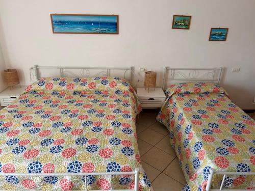 a bedroom with two beds and two night stands at Foresteria Kiki in Gravedona