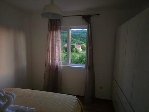 a bedroom with a window with a view of a house at Sofija in Radanovići